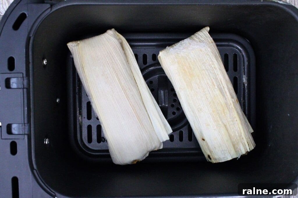 place frozen trader joes tamales wrapped in the husk in air fryer basket