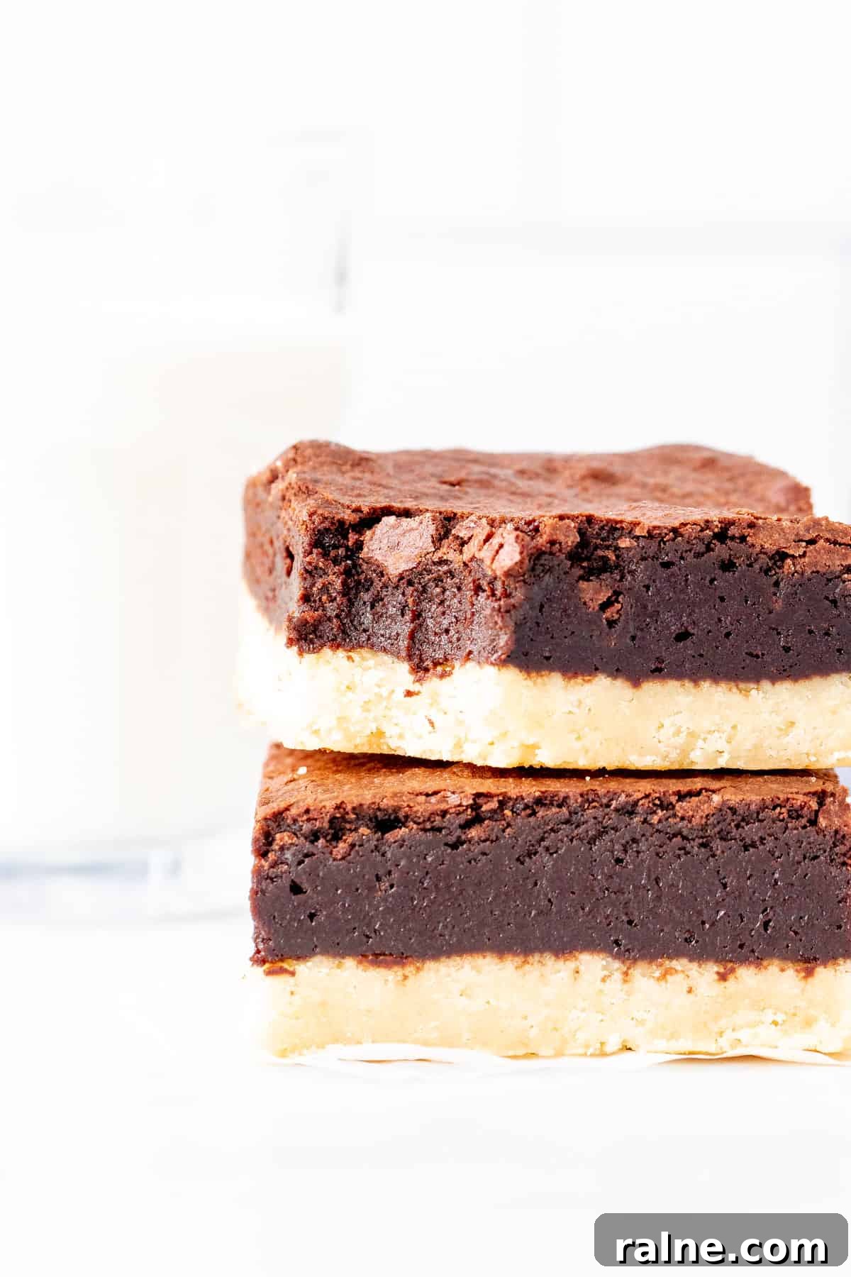 Shortbread Brownies Recipe: Buttery Crust and Fudgy Center 6 Two brownies with a shortbread crust, stacked one on top of each other.
