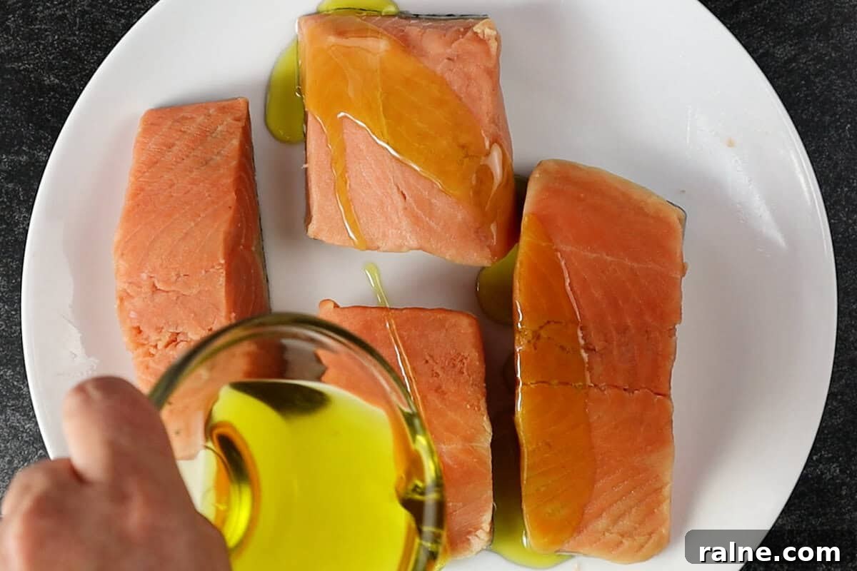 Grilled Salmon with Fresh Mango Salsa Recipe 7 coating salmon in olive oil on white plate.