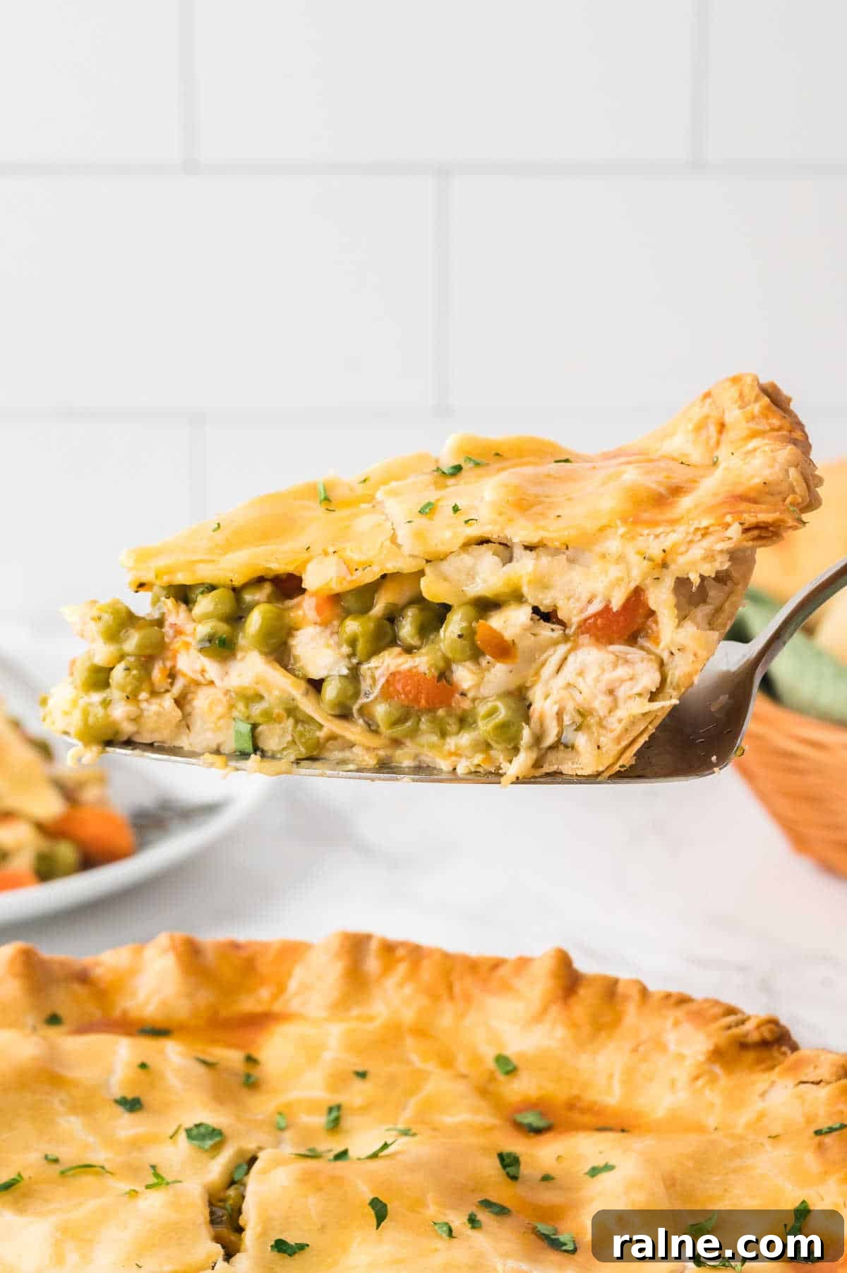 Homemade Chicken Pot Pie Recipe with Flaky Golden Crust 6 A pie server with a slice of chicken pot pie.