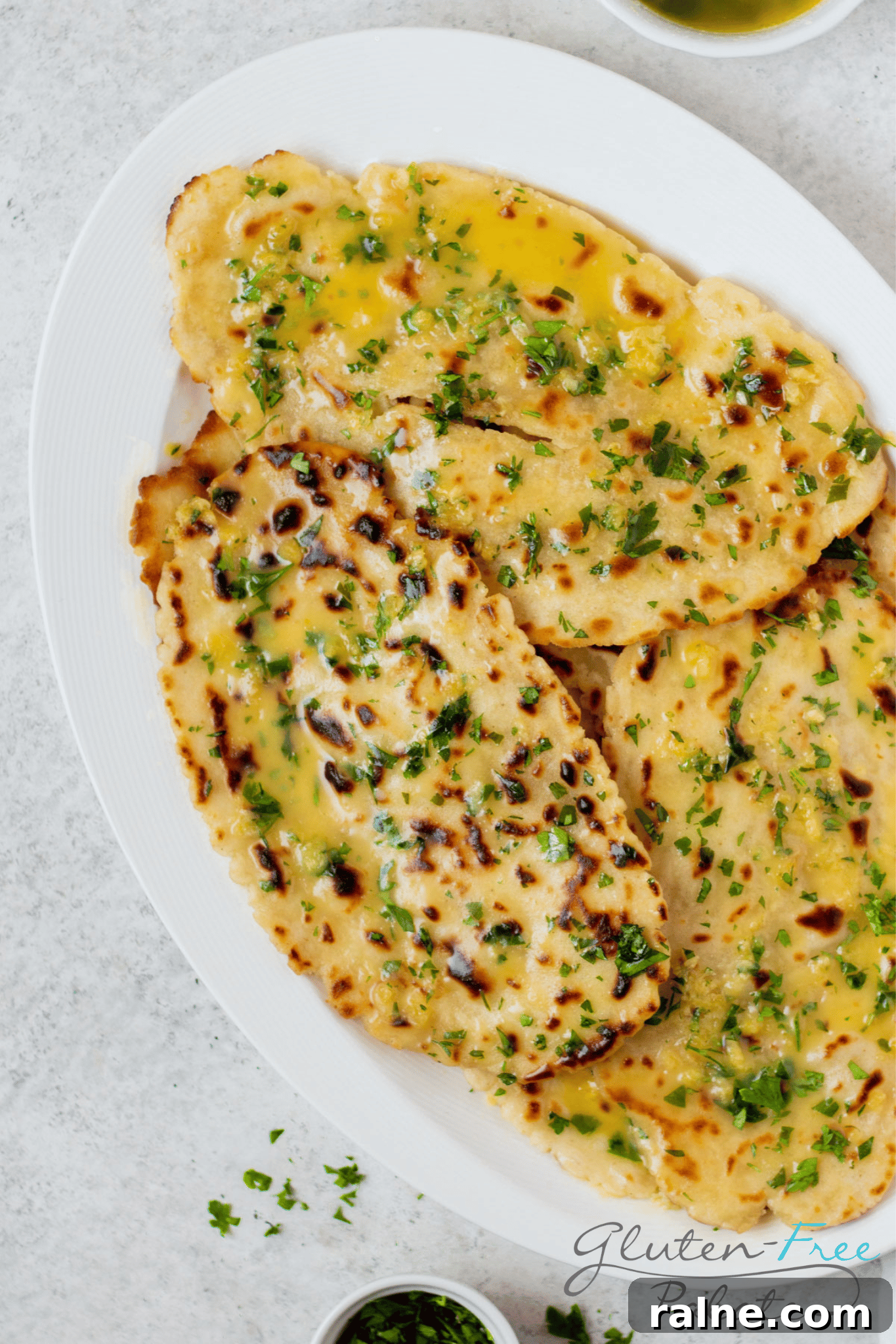 Gluten-Free Naan Recipe: Soft, Quick Homemade Flatbread 7 a white oval plate stacked with homemade gluten free naan