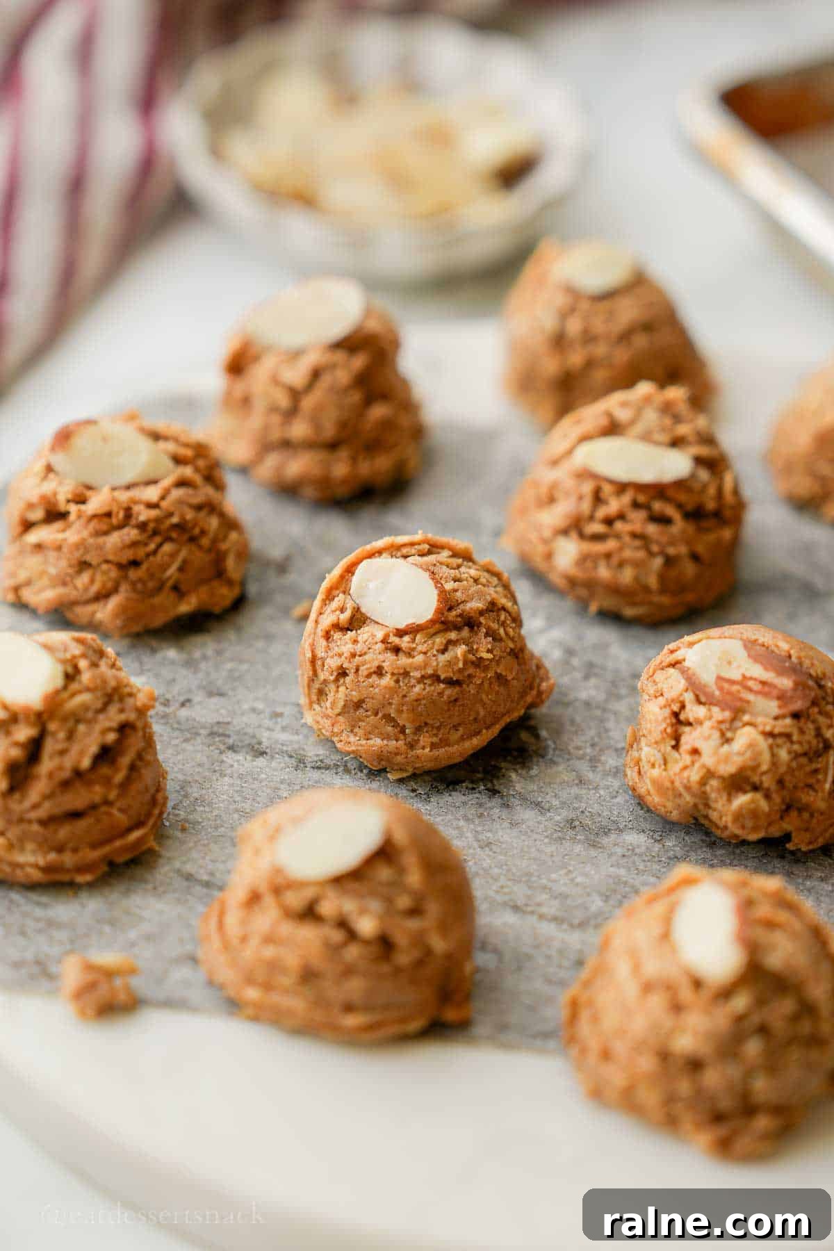 Almond Butter Protein Energy Bites for On-the-Go Snacks 2 Almond butter protein bite on marble with almond slice.