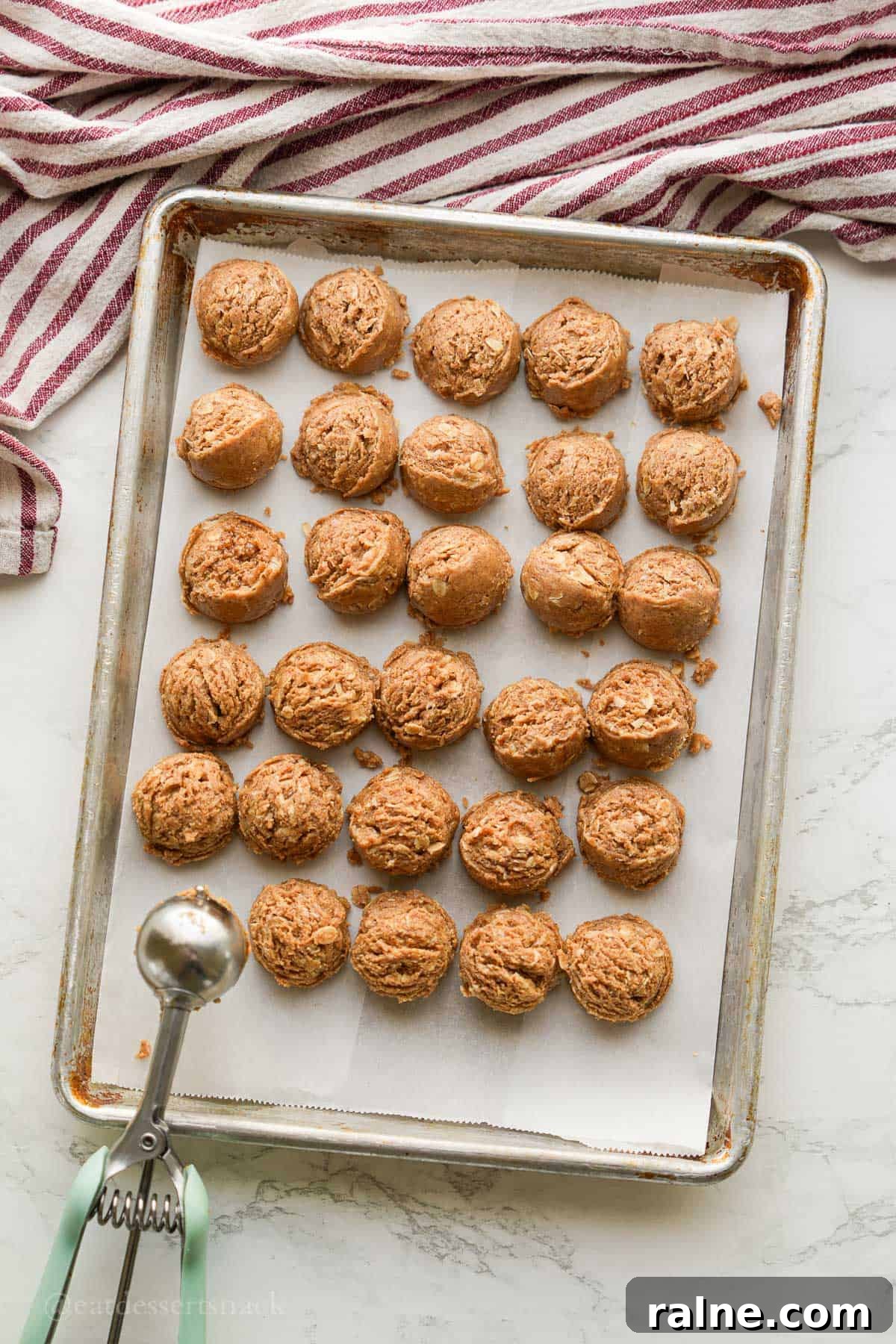 Almond Butter Protein Energy Bites for On-the-Go Snacks 6 Scooping almond butter bites onto baking sheet.