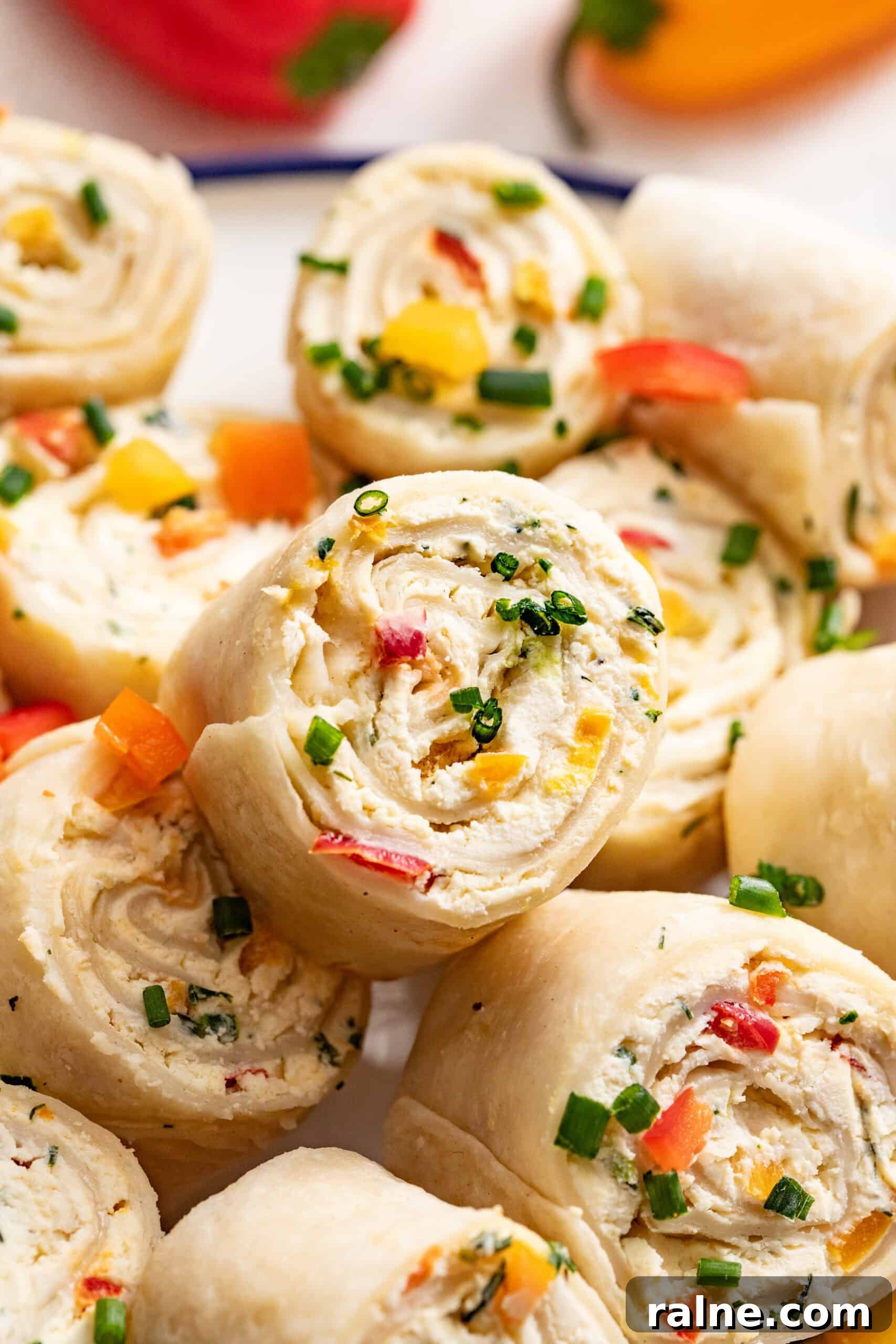 Cream Cheese Tortilla Roll-Ups: 5-Minute Party Appetizer Recipe 2 A close up shot of peppers and cream cheese rolled into a tortilla pinwheel.