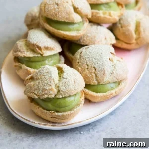 Matcha Cream Puffs Recipe: Light, Airy Japanese Choux Pastry 13 Matcha Cream Puffs arranged on pink serving plate.