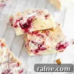 A close up picture of two white chocolate raspberry blondies stacked on each other.