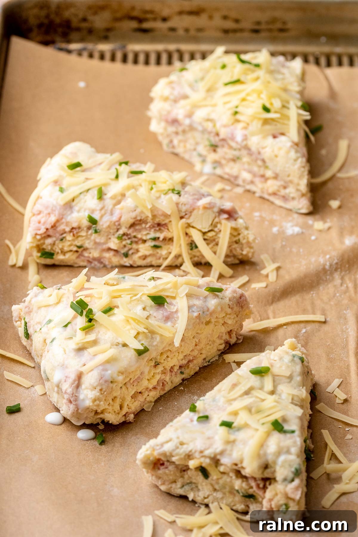 Savory Ham and Cheese Scones Recipe for Brunch or Snacks 11 Ham and cheese scones topped with cheese and chives before baking.