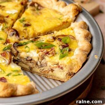 Sliced bacon mushroom quiche in a pie plate.