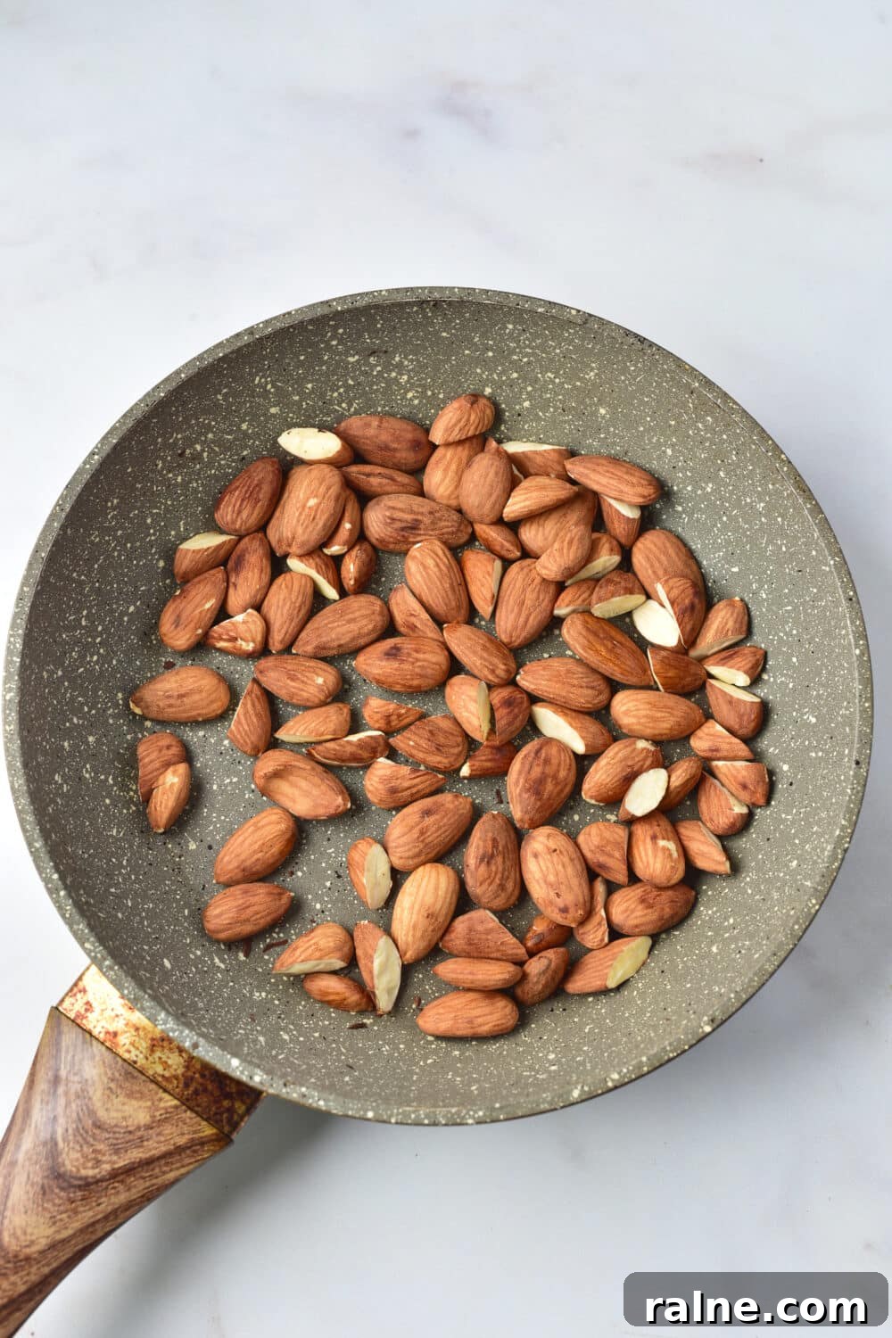 White Chocolate Almond Bark Recipe — Quick No-Bake Treat 4 almonds toasting in skillet
