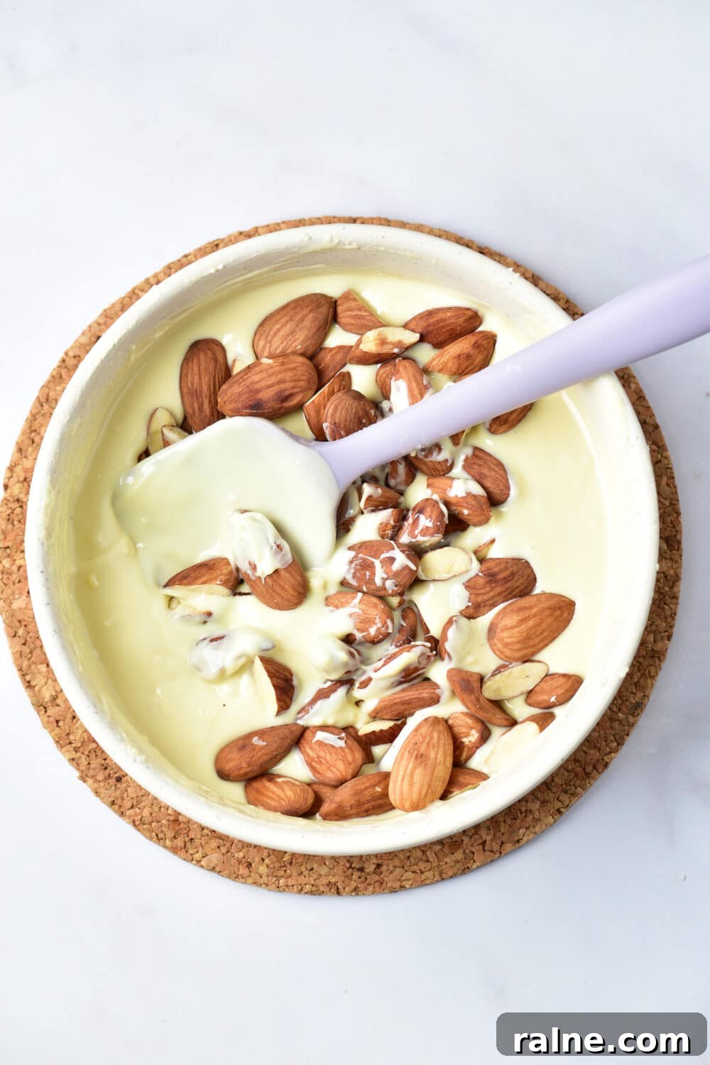 White Chocolate Almond Bark Recipe — Quick No-Bake Treat 8 melted white chocolate and almonds in a bowl