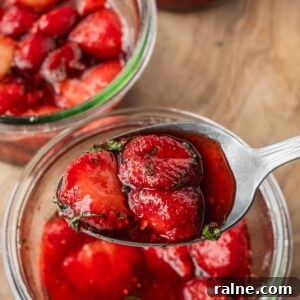 A spoonful of macerated strawberries with sliced basil.