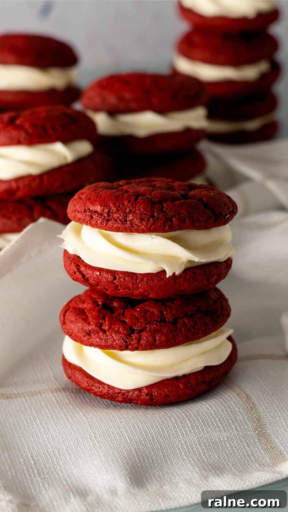 Decadent Red Velvet Whoopie Pies Recipe for Perfect Sandwich Cookies 2 Two Red Velvet Whoopie Pies stacked on top of eachother on a white linen napkin.