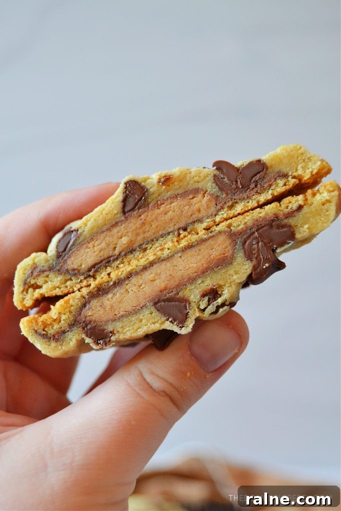 blogger holding a split open peanut butter cup stuffed cookie