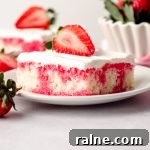 Strawberry Jello Poke Cake Recipe — Moist, Creamy Dessert 20 slice of strawberry poke cake on a plate