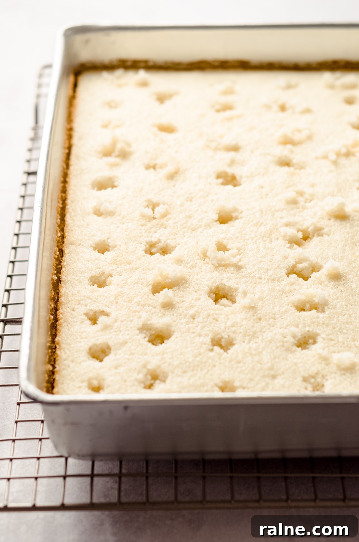 Strawberry Jello Poke Cake Recipe — Moist, Creamy Dessert 10 holes poked in cake to make poke cake