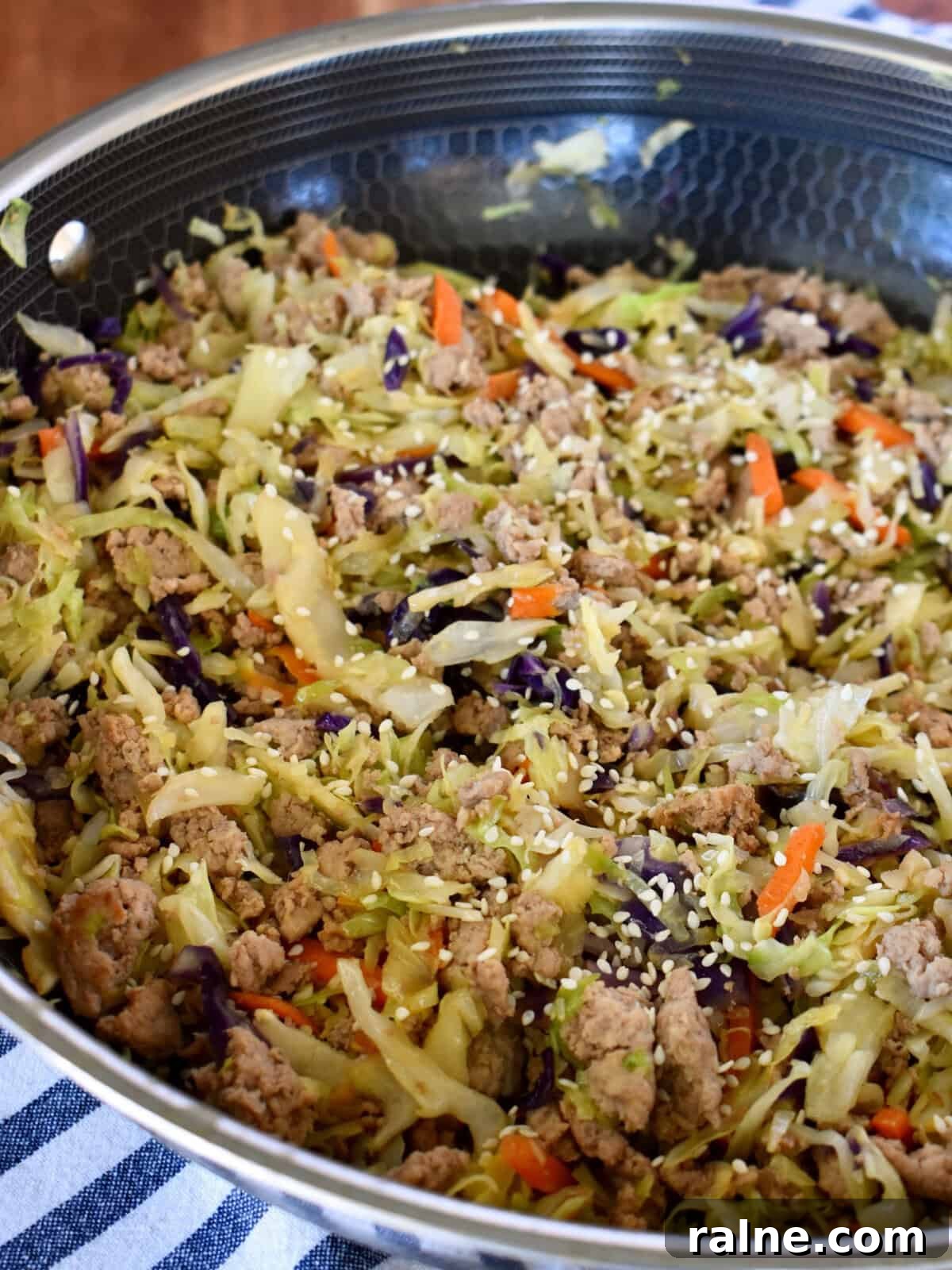 Egg roll in a bowl with ground turkey in a large pan. 