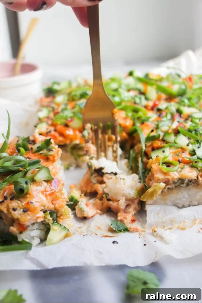 Spicy Tuna Crispy Rice Paper Cups Recipe for Impressing Guests 11 A fork piercing into a piece of salmon sushi bake.