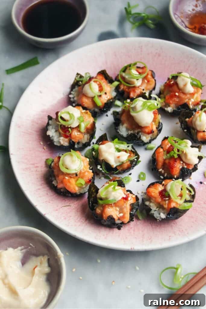 Spicy Tuna Crispy Rice Paper Cups Recipe for Impressing Guests 12 Salmon sushi cups on a pink plate, with aioli and sweet chilli on the side.