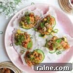 Five tuna rice paper cups on a pink plate.