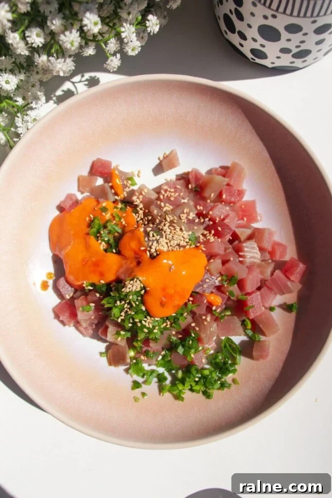 Spicy Tuna Crispy Rice Paper Cups Recipe for Impressing Guests 4 Diced tuna in a pink bowl with spicy mayo, scallions and sesame seeds.