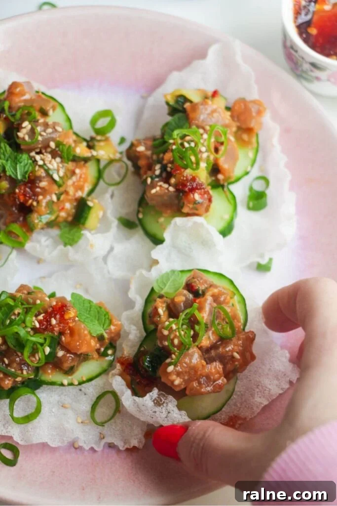 Spicy Tuna Crispy Rice Paper Cups Recipe for Impressing Guests 9 Four tuna rice paper cups on a pink plate.