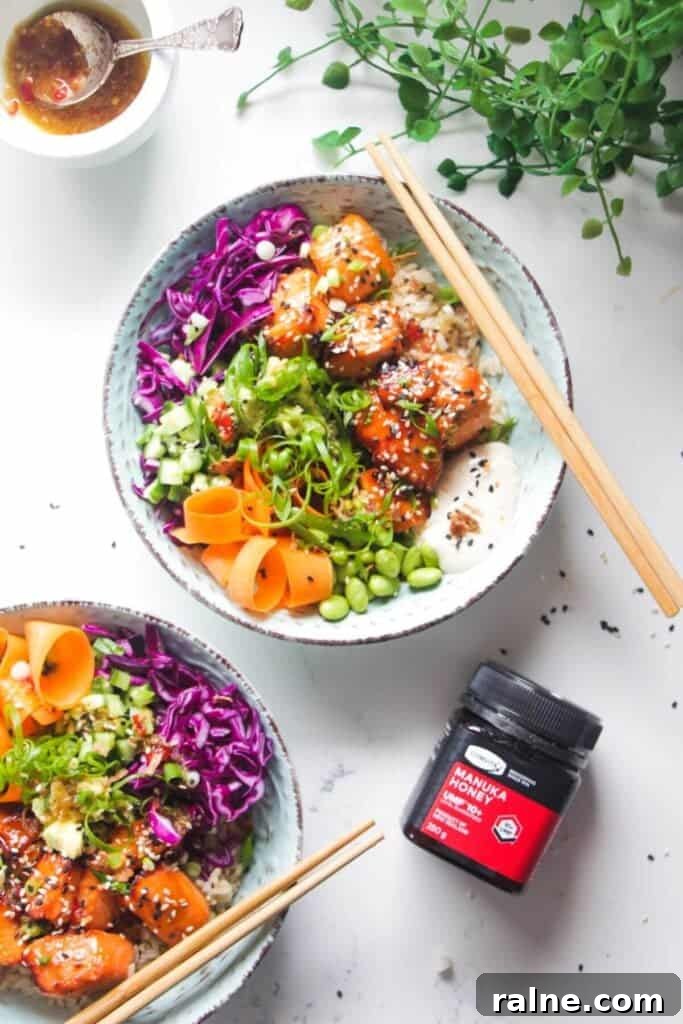 Spicy Tuna Crispy Rice Paper Cups Recipe for Impressing Guests 10 Two baked salmon poke bowls on a marble background with honey on the side.