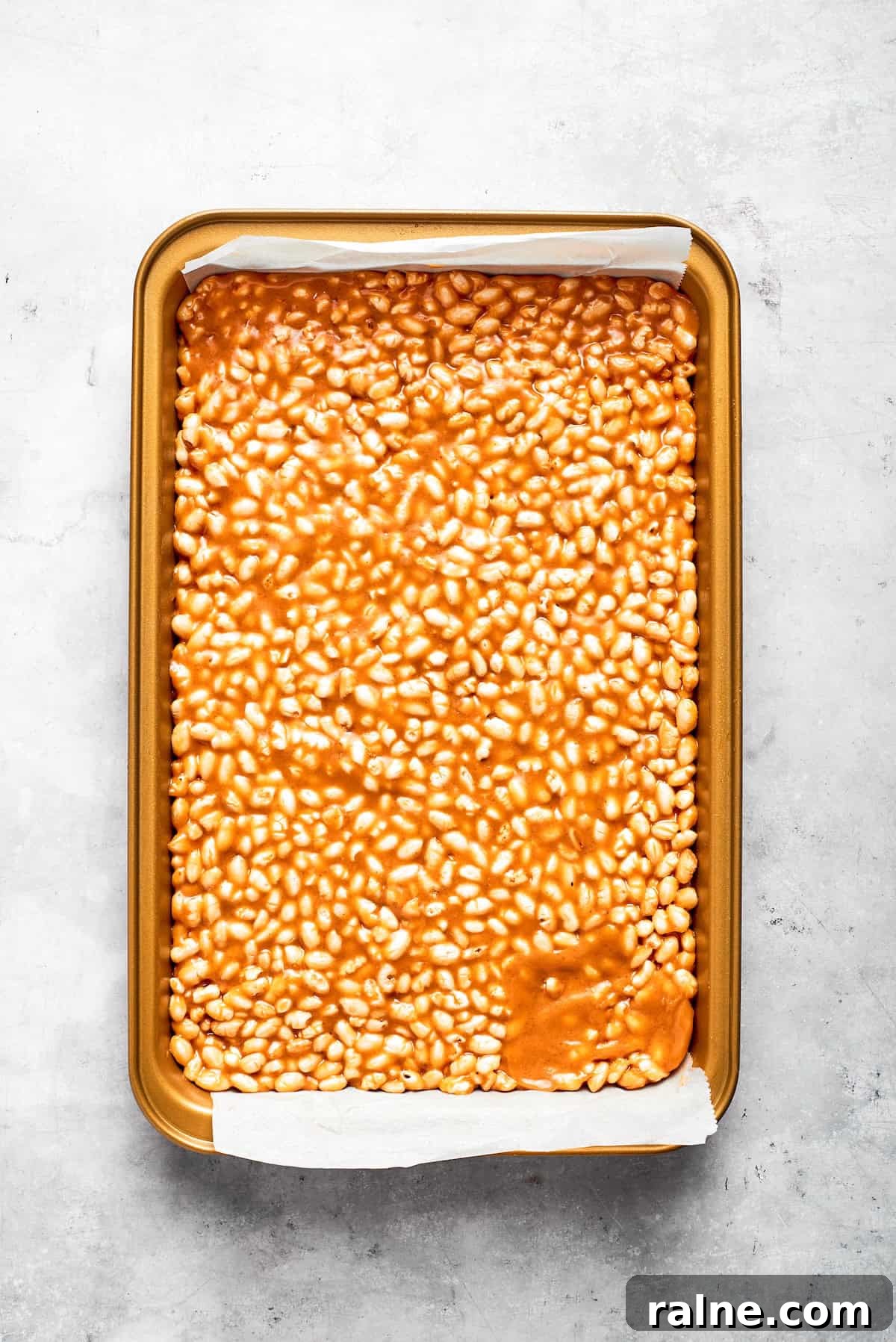 No-bake scotcharoos feature creamy peanut butter, crispy rice cereal, and a sweet layer of melted chocolate and butterscotch. Scotcharoos base pressed into a baking pan.
