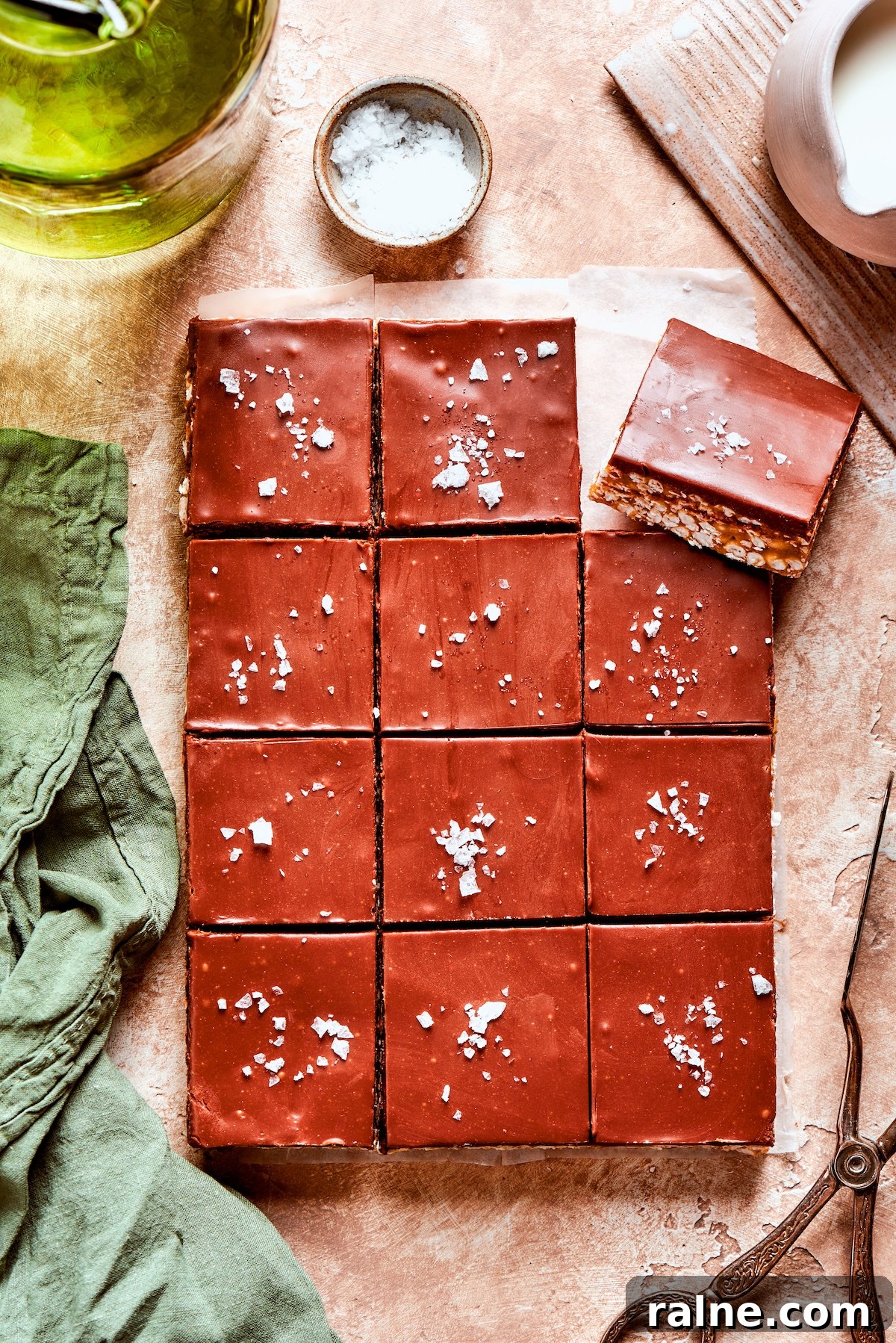 No-bake scotcharoos feature creamy peanut butter, crispy rice cereal, and a sweet layer of melted chocolate and butterscotch. Flaky salt is added to a dozen scotcharoos.