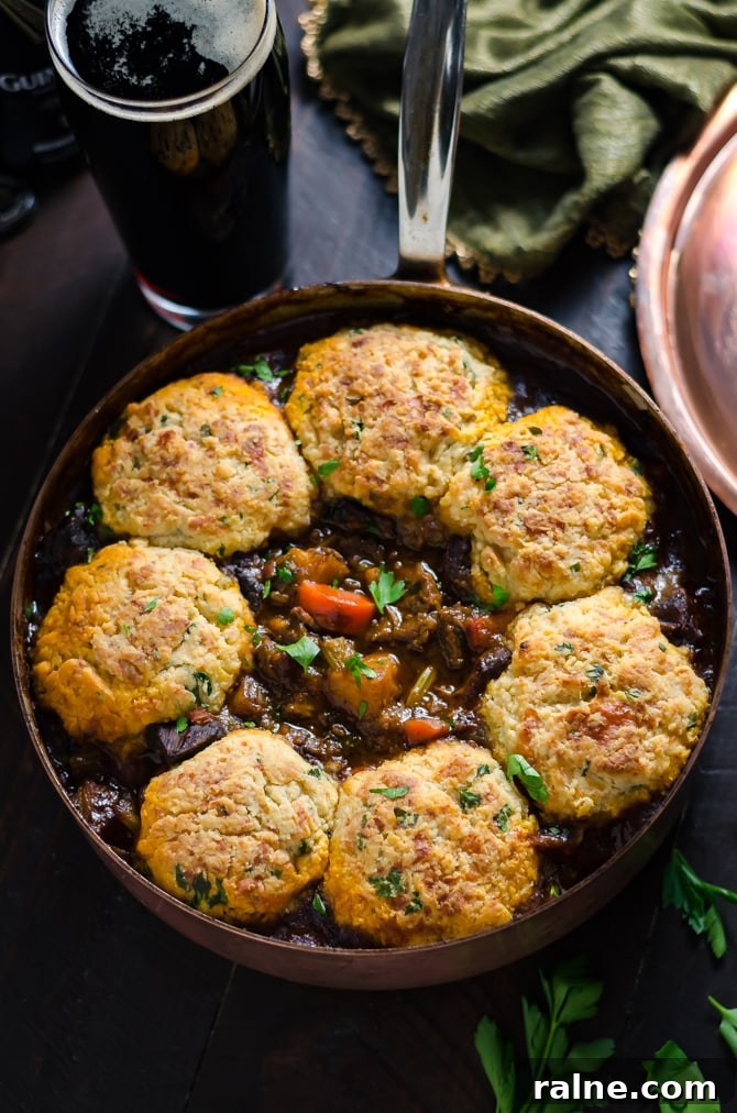 Guinness Beef Stew with Cheddar Herb Dumplings. Rich, comforting, and deeply flavorful.