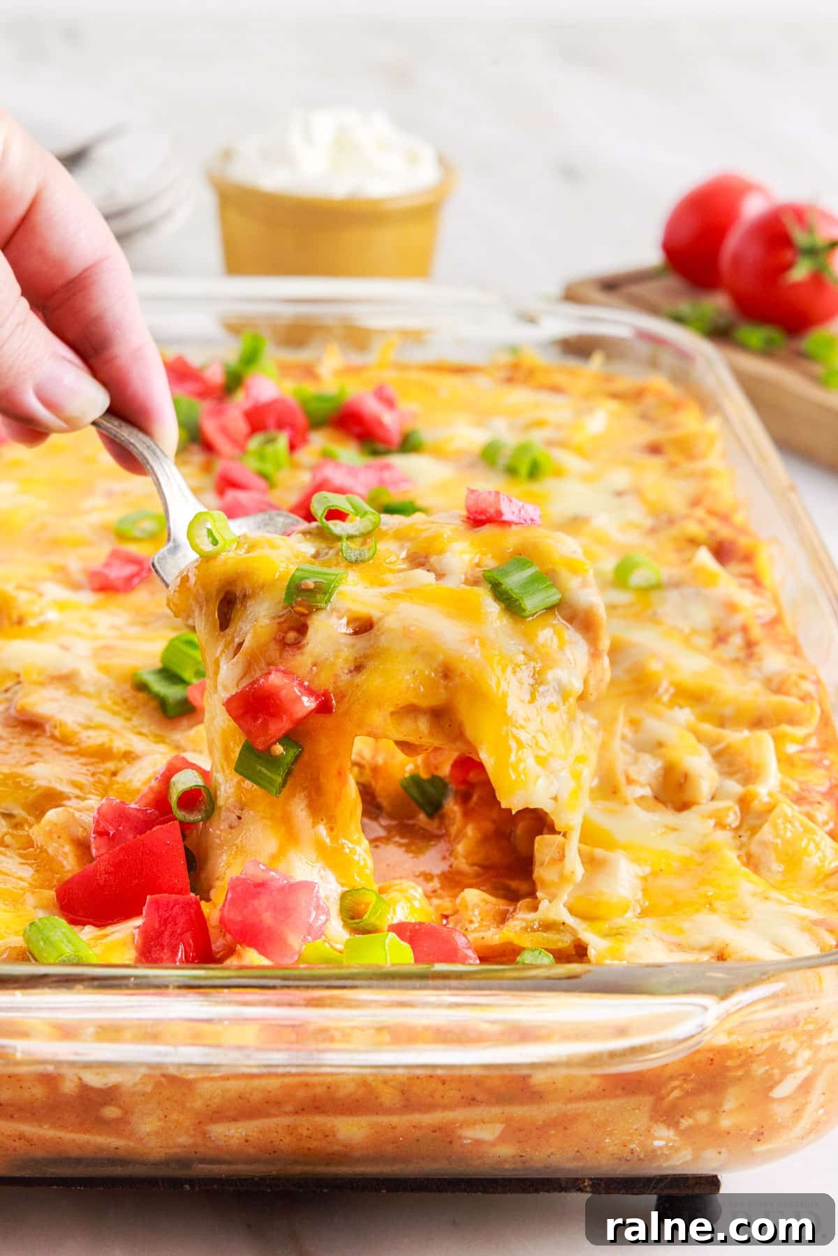 A fork full of turkey enchilada casserole lifted out of 9x13.