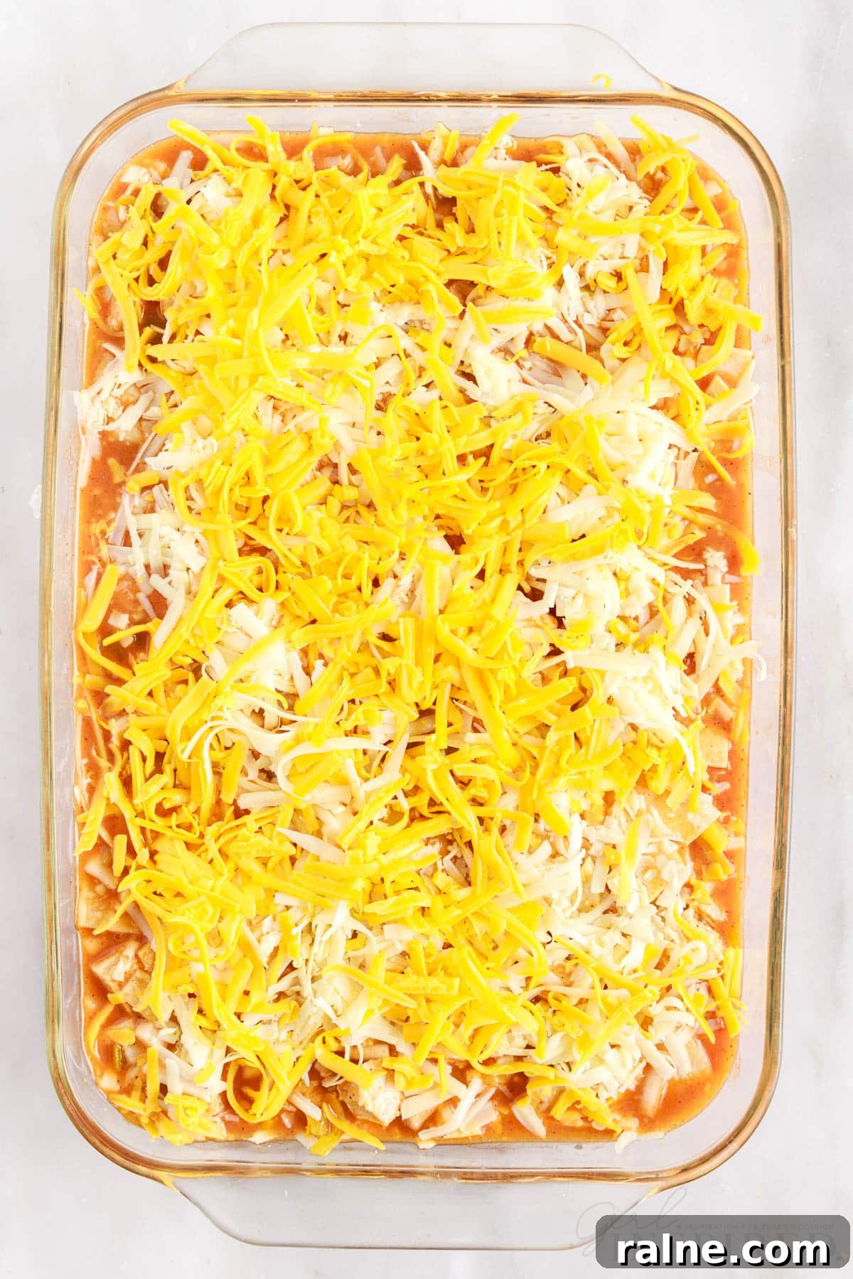 cheese sprinkled on top of turkey pieces in a 9x13