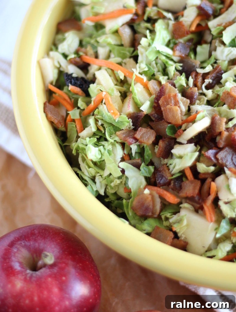Apple Bacon Brussels Sprouts Salad - this Paleo and AIP-friendly salad is perfect for Fall! Complete with crispy bacon, dried cherries, fresh apples, carrots, and an apple cider vinaigrette!