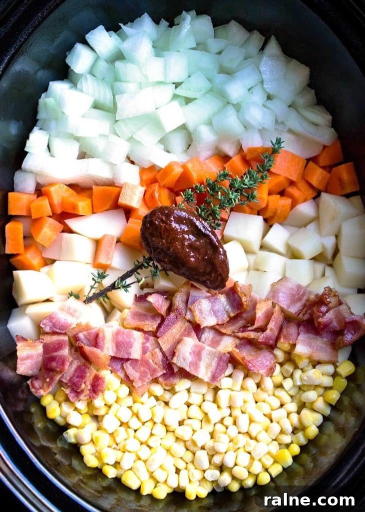 Creamy Slow Cooker Corn Chowder Recipe for Cozy Weeknights 4 overhead: diced potatoes onions and carrots with bacon and corn in crock pot
