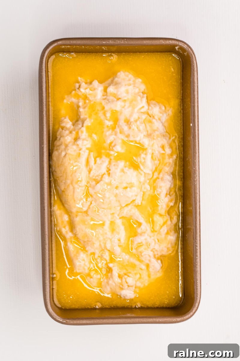 No-Fuss Beer Bread Recipe: Crispy Crust, Tender Inside 7 beer bread dough in a loaf pan covered in melted butter