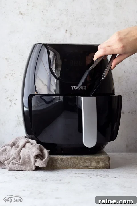 T17067 Tower Air Fryer Review: Real Results and Key Features 7 Someone taking food out a Tower air fryer with tongs