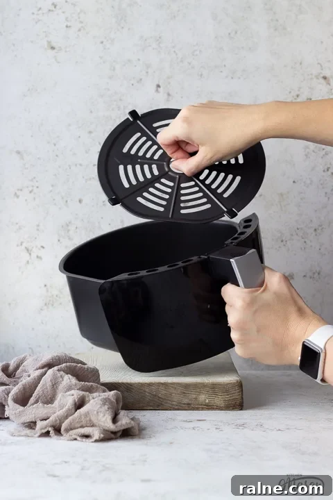 T17067 Tower Air Fryer Review: Real Results and Key Features 3 Someone taking the crisper tray out of a Tower air fryer drawer