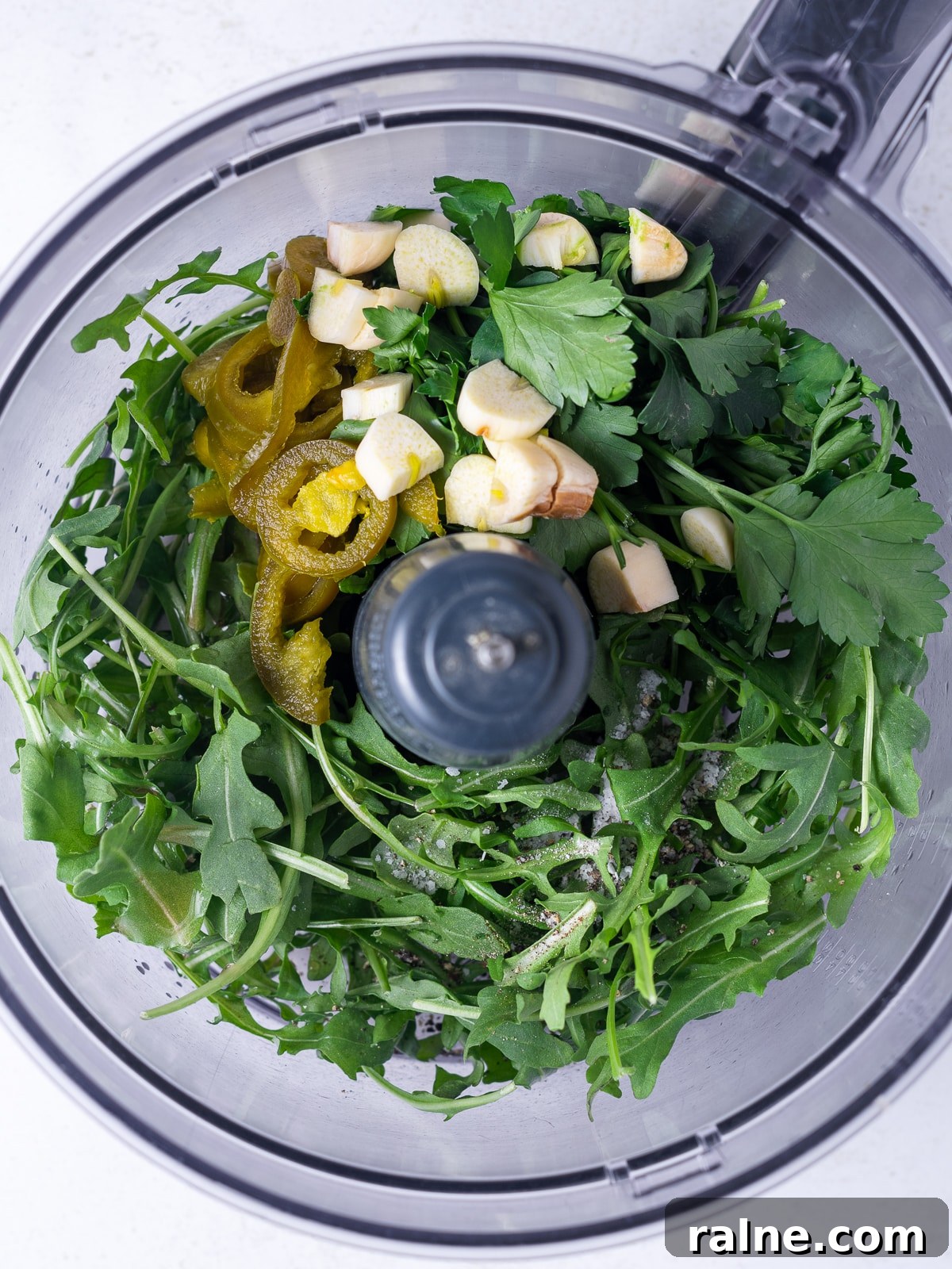 Arugula Chimichurri Sauce Recipe for Grilled Meats & Veggies 4 food processor bowl with arugula, parlsey, pickled jalapeno, garlic, red wine vinegar, salt and pepper