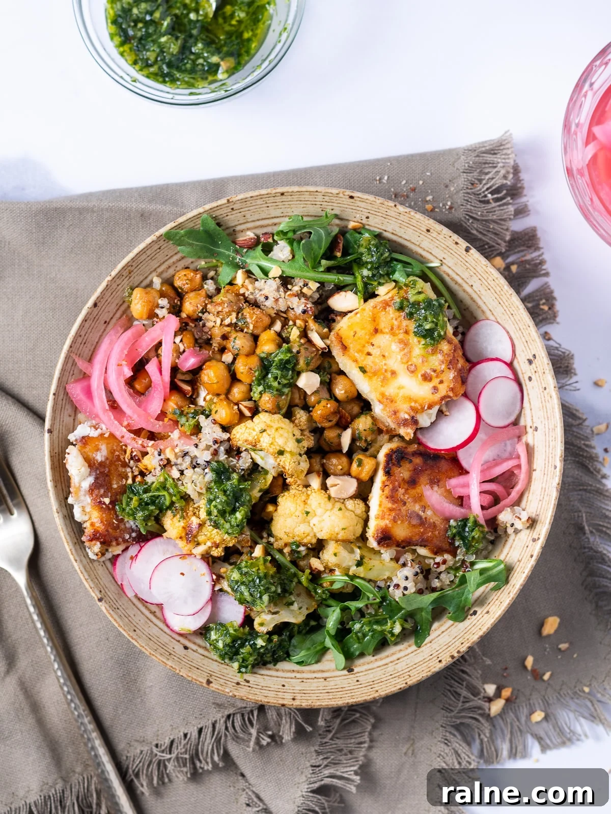 Arugula Chimichurri Sauce Recipe for Grilled Meats & Veggies 7 bowl of food feauring chimichurri coated cauliflower and chickpeas, quinoa, fried feta and pickled red onions