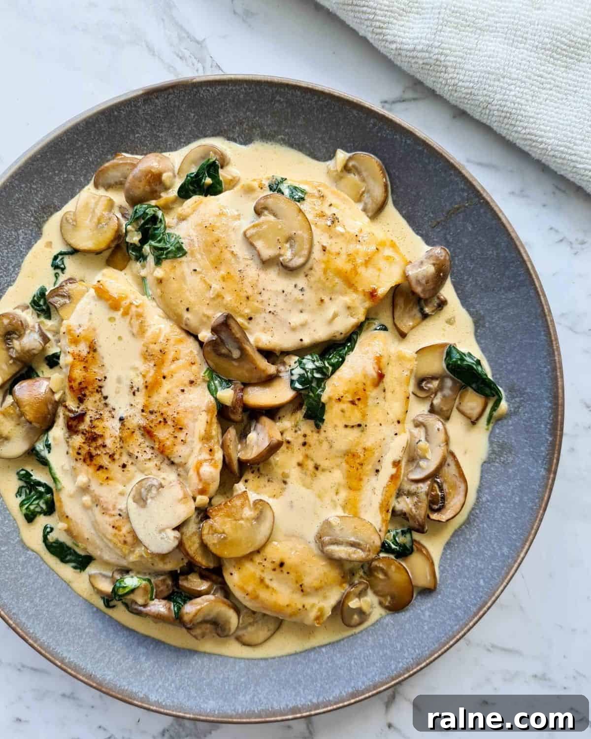 A full plate of cooked chicken with creamy mushrooms