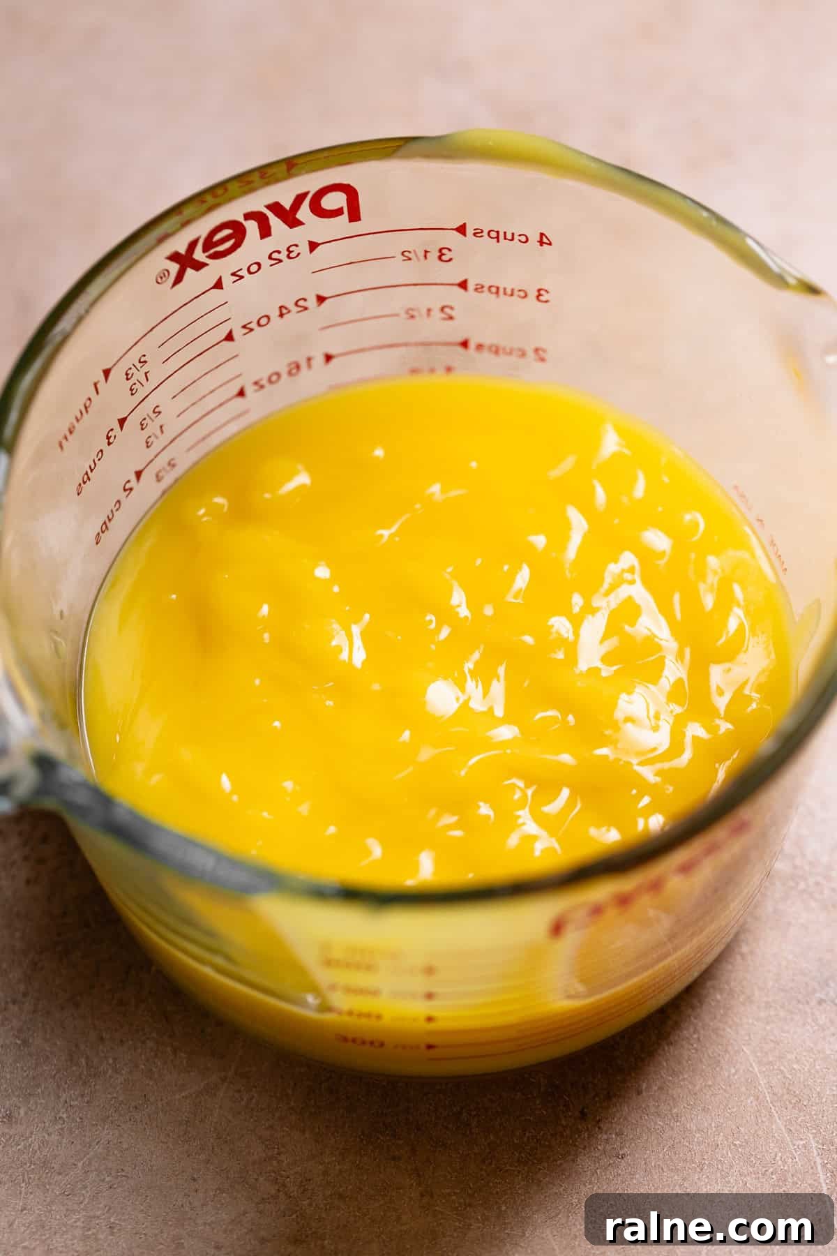 Classic Lemon Bars with Buttery Shortbread Crust 6 Lemon curd in a glass measuring cup.