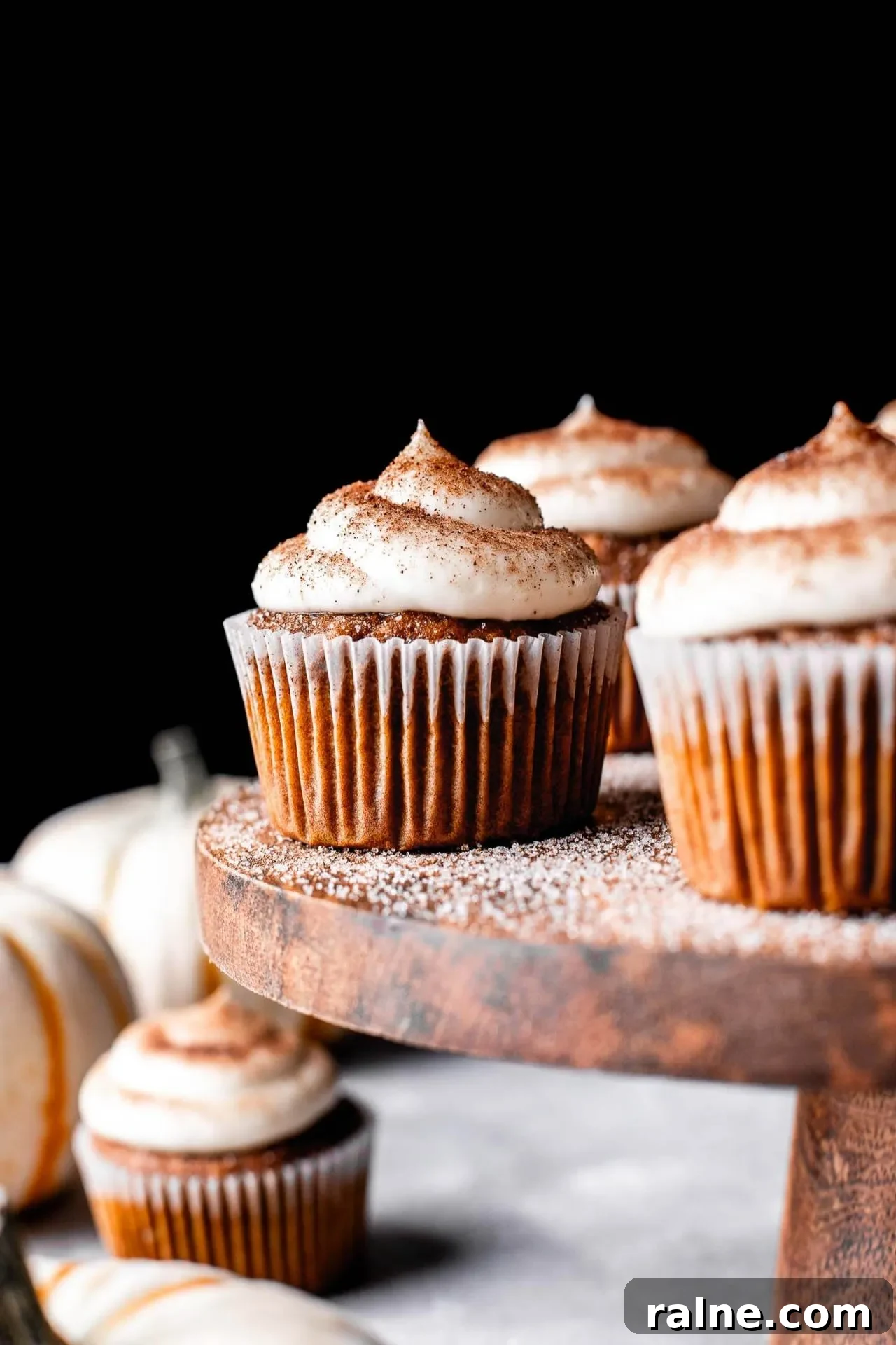 Pumpkin Spice Latte Cupcakes: Moist Espresso-Infused Fall Treats 13 frosted pumpkin spice latte cupcakes on wooden cake stand with pumpkin spice sugar sprinkled on top (8)