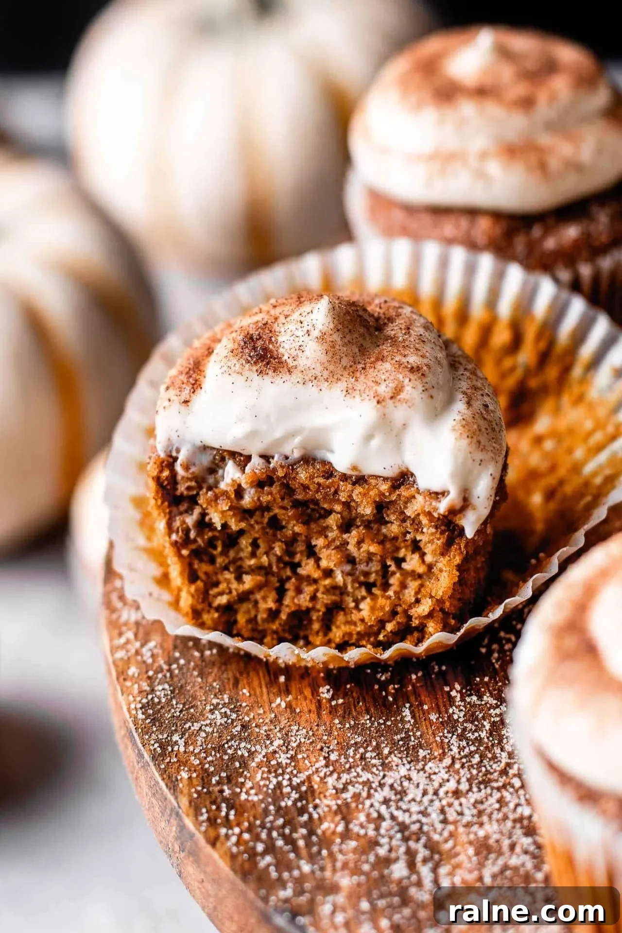 Pumpkin Spice Latte Cupcakes: Moist Espresso-Infused Fall Treats 4 frosted pumpkin spice latte cupcakes on wooden cake stand with pumpkin spice sugar sprinkled on top (11)
