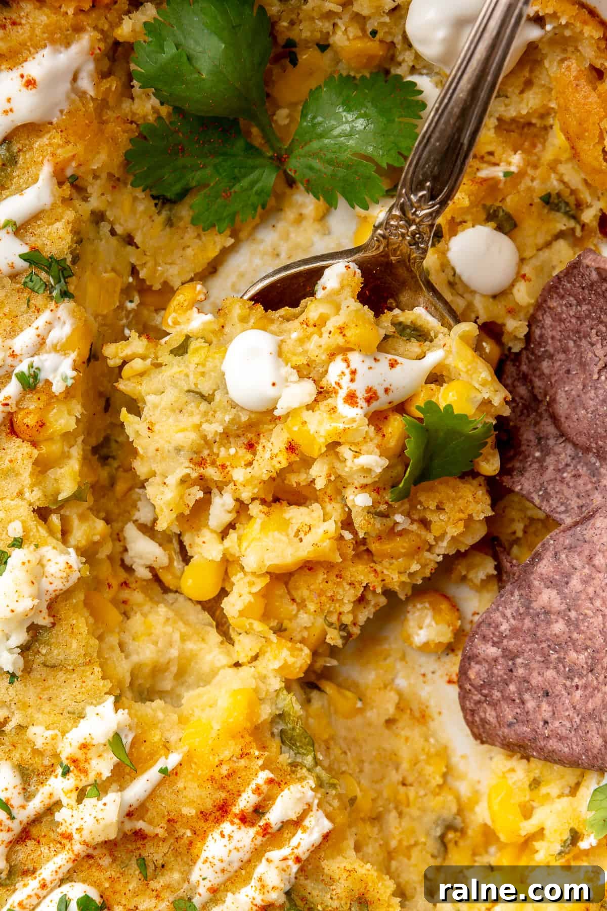 Creamy Mexican Corn Casserole with Cheesy Jalapeño Bake 2 Spoon scooping up mexican corn casserole.