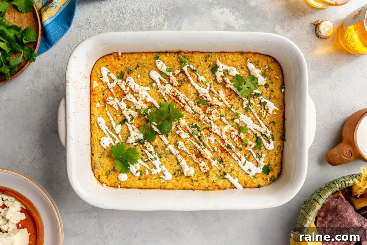 Creamy Mexican Corn Casserole with Cheesy Jalapeño Bake 7 White baking dish with baked Mexican corn casserole.