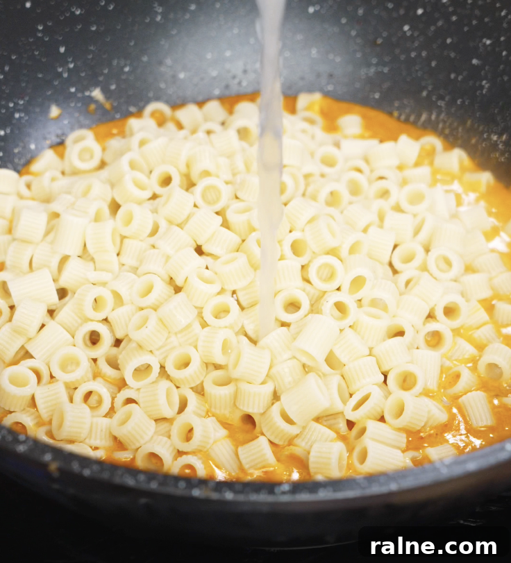 Cooked pasta is added to the creamy chili sauce and tossed together with pasta water for a glossy finish.