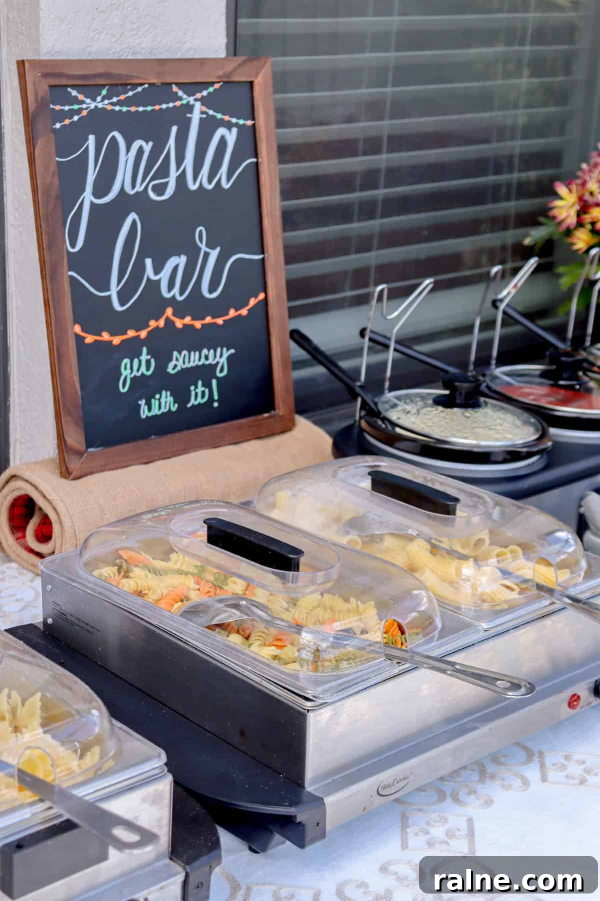 Party Pasta Bar Ideas: How to Set Up a Crowd-Pleasing Pasta Station 4 Pasta bar sign with chafing dishes and sauces in crock pots.