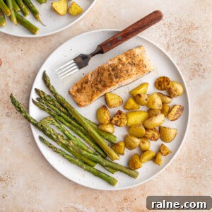Sheet Pan Salmon Asparagus and Potatoes on a plate with a fork