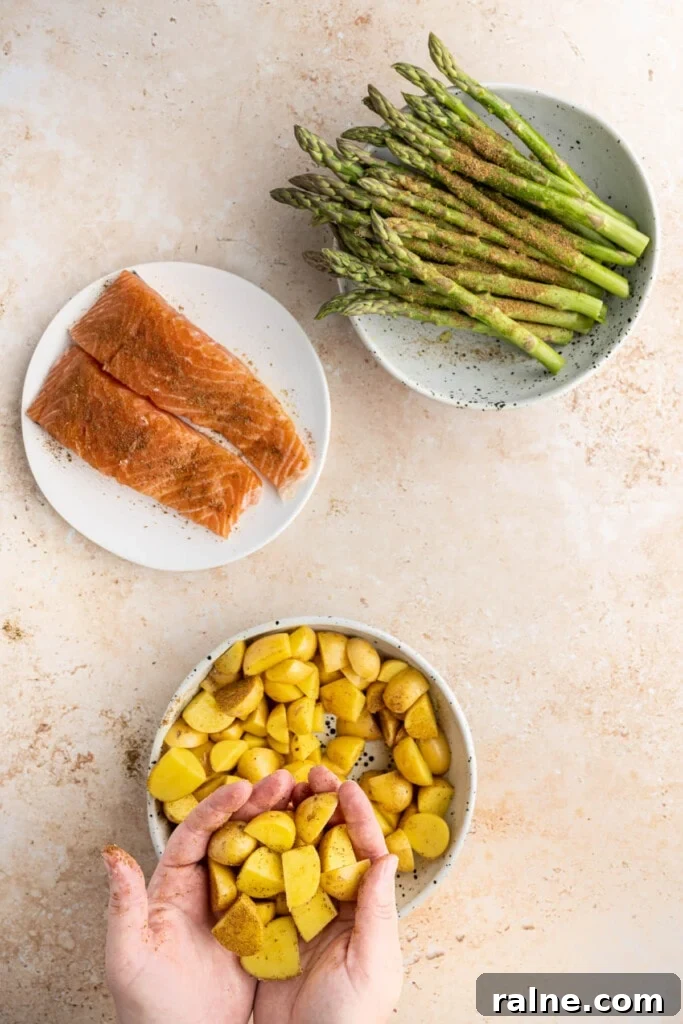 Adding Old Bay Seasoning to veggies and fish and tossing to coat.