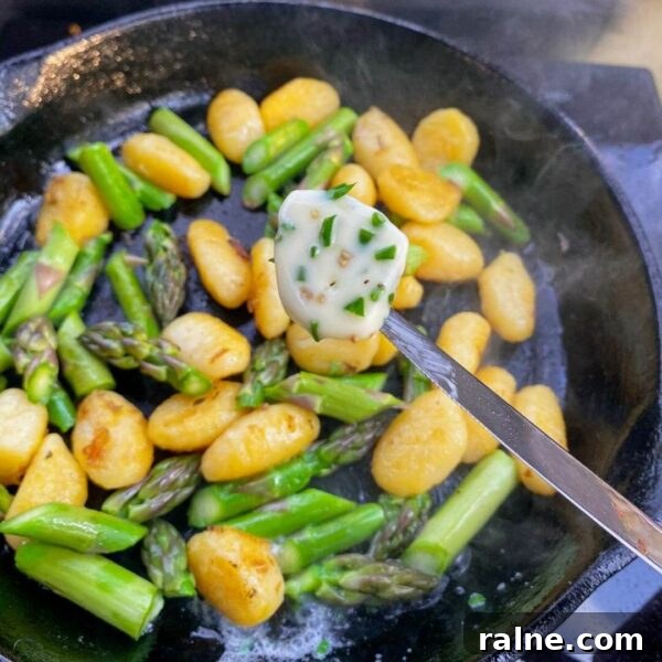 11 Flavorful Ways to Season Vegetables for Every Meal 8 pat of herb butter over gnocchi and asparagus in cast iron fry pan