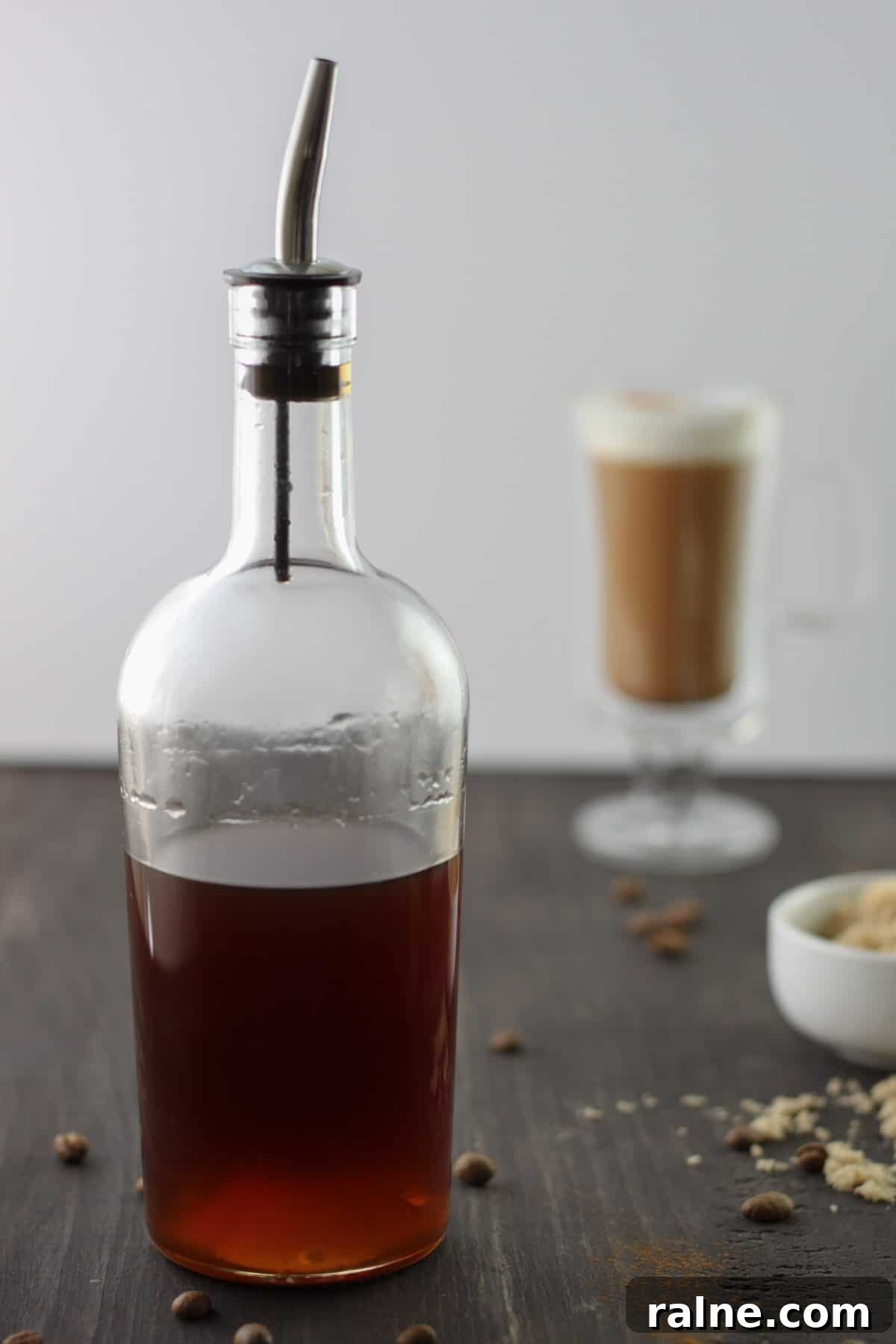 Brown Sugar Simple Syrup Recipe for Cocktails and Coffee 2 Brown sugar simple syrup in a glass bottle on a dark brown table.